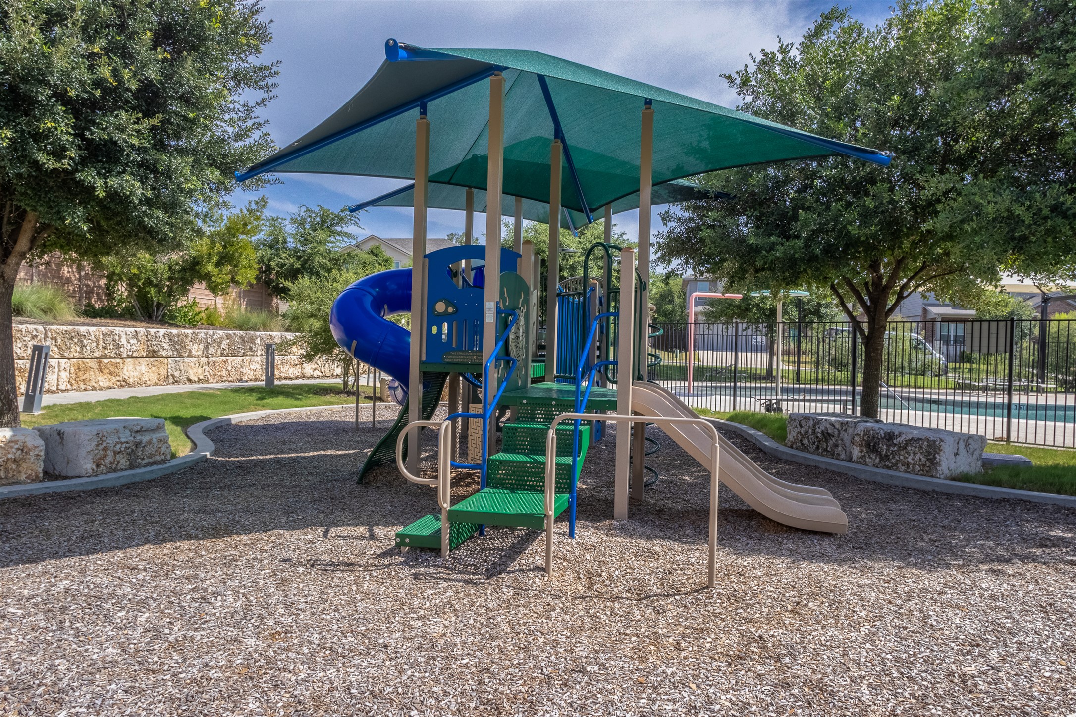 7225 Ranchito Drive Austin, TX 78744 - Photo 34 of 39 A well-maintained playground awaits with a sturdy play structure and soft wood chip ground cover.