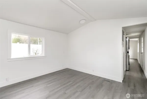 an empty room with wooden floor and a window