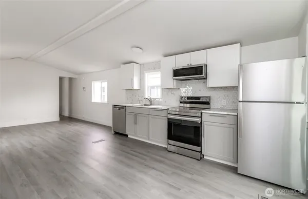 a kitchen with stainless steel appliances a refrigerator sink and white cabinets
