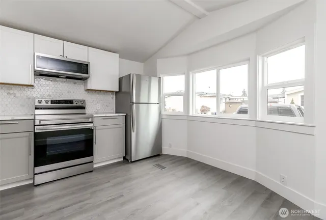 a kitchen with stainless steel appliances a stove a sink and a refrigerator
