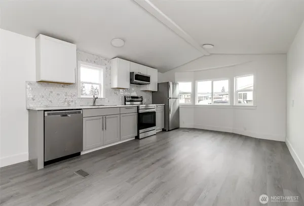 a kitchen with a sink a window and stainless steel appliances