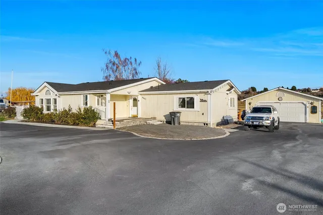 a view of a white house and a car parked on road