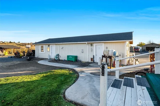 a view of a big house with large trees and outdoor seating
