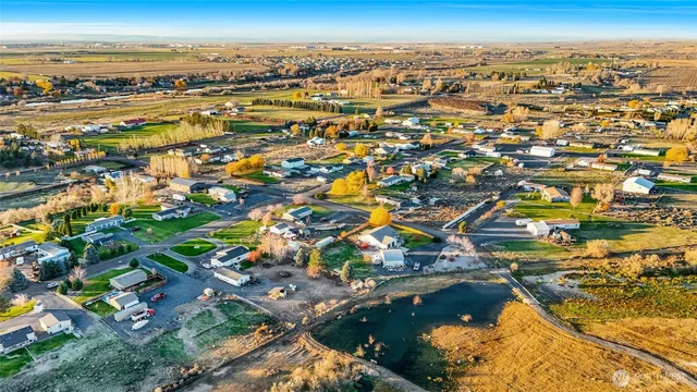 an aerial view of a house with a yard and large trees
