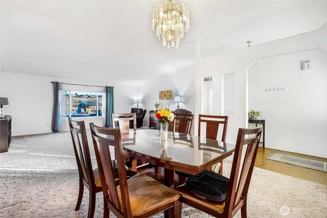 a view of a dining room with furniture and chandelier