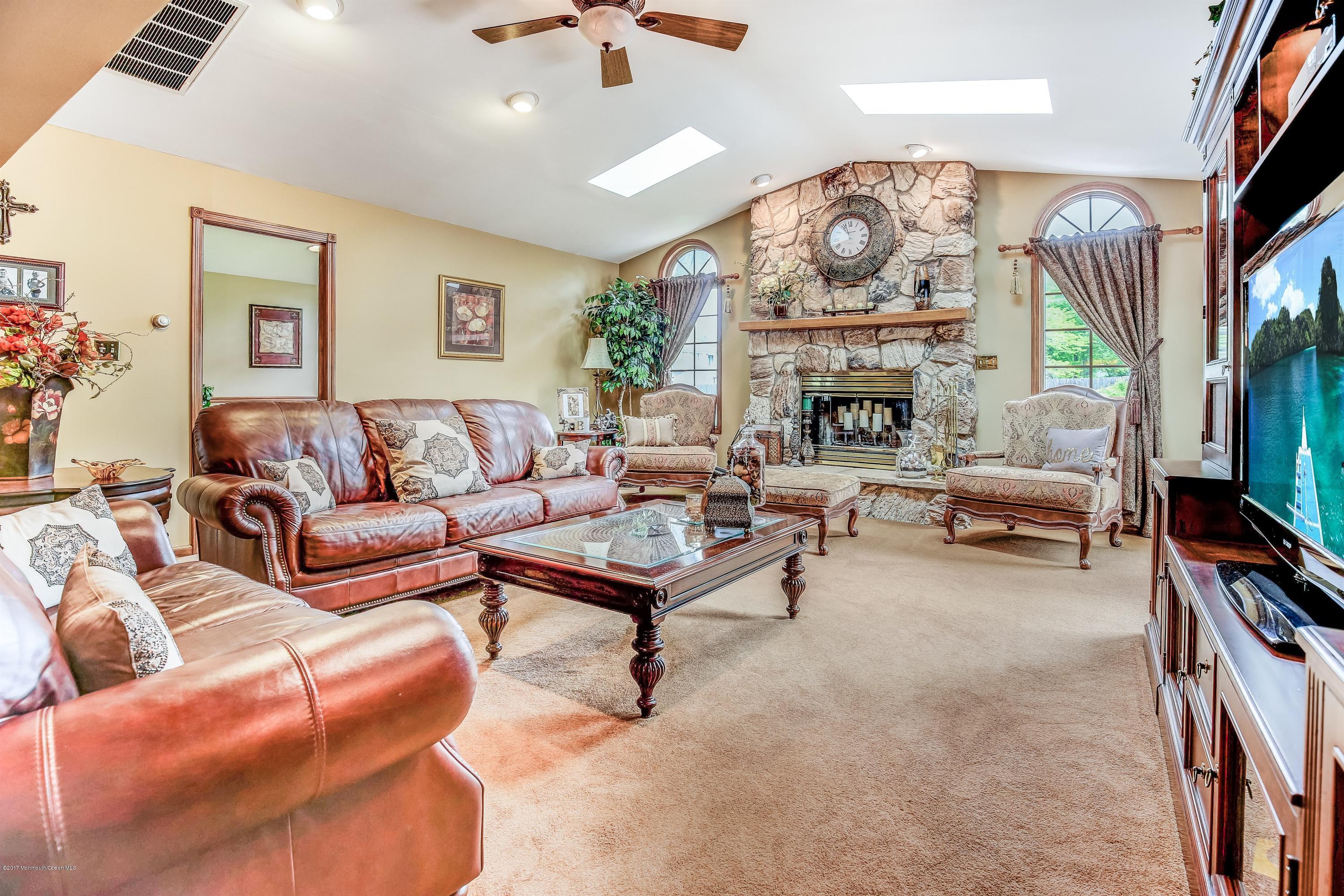 11 Applegate Road Freehold, NJ 07728 - Photo 5 of 23 a living room with furniture a fireplace and a flat screen tv