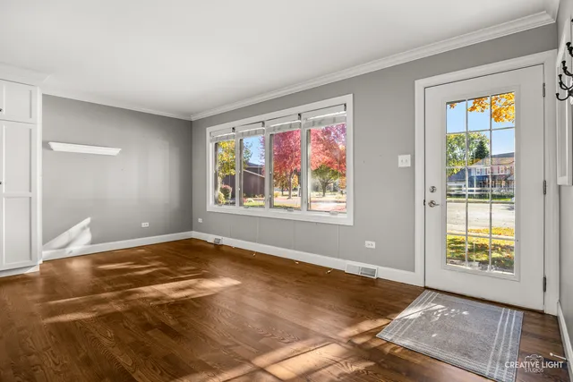 a large kitchen with wooden floor and stainless steel appliances