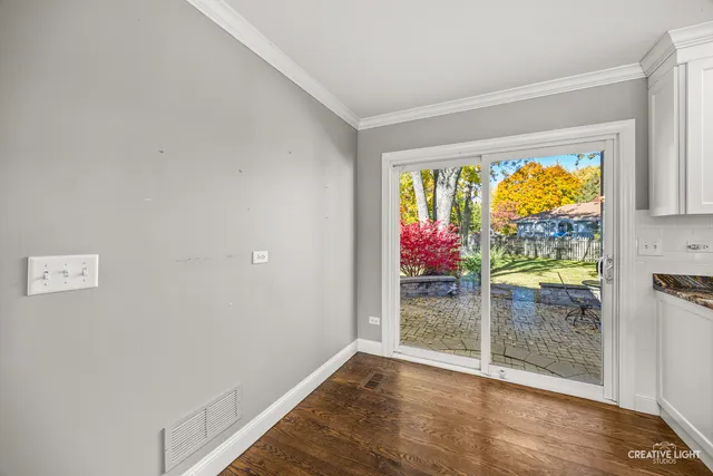 an empty room with wooden floor a fireplace and window