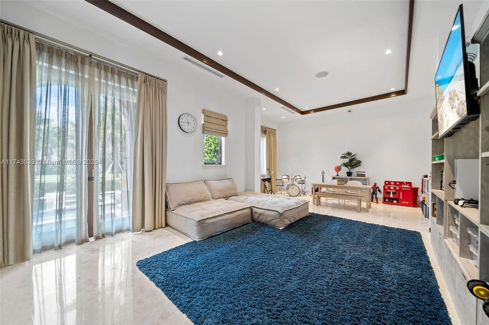 8955 Southwest 63rd Court Pinecrest, FL 33156 - Photo 40 of 59 a living room with furniture and a flat screen tv