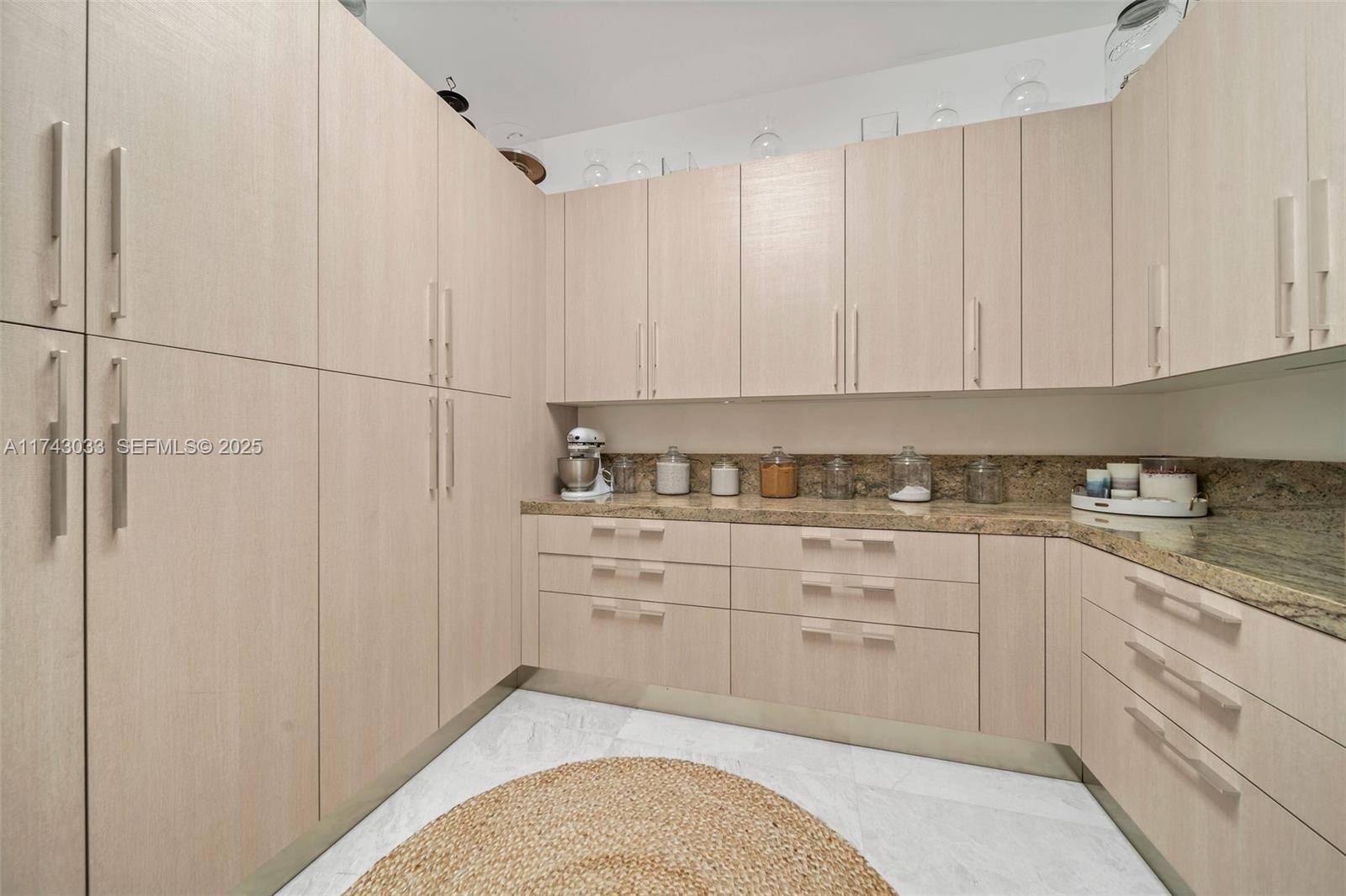 8955 Southwest 63rd Court Pinecrest, FL 33156 - Photo 47 of 59 a kitchen with granite countertop white cabinets and sink