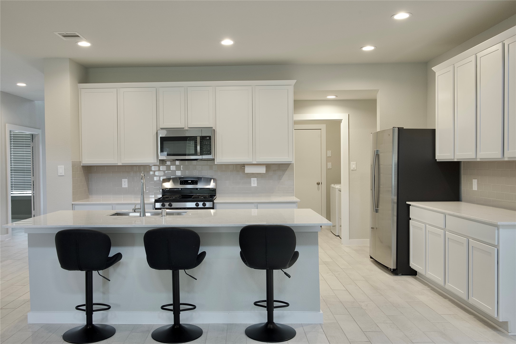 3207 Tilley Drive Rosenberg, TX 77471 - Photo 12 of 43 a kitchen with stainless steel appliances granite countertop a refrigerator a stove a sink cabinets and a dining table with chairs