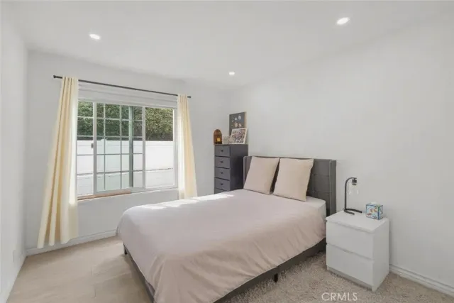 a large bed sitting in a bedroom next to a window