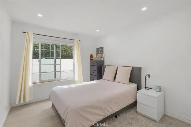 a large bed sitting in a bedroom next to a window