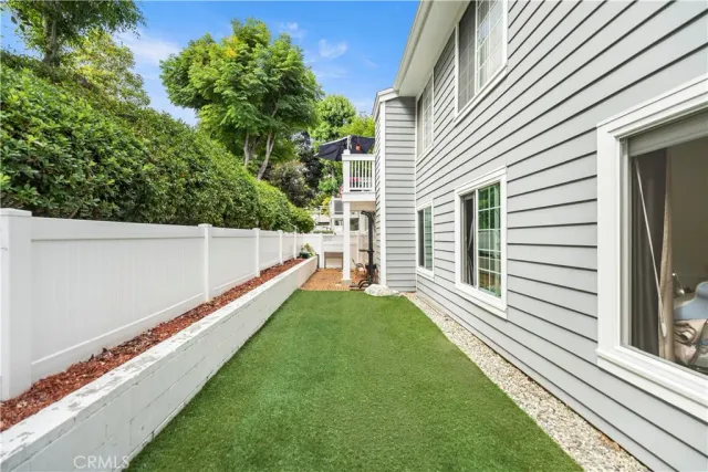a view of a white house with a yard and potted plants