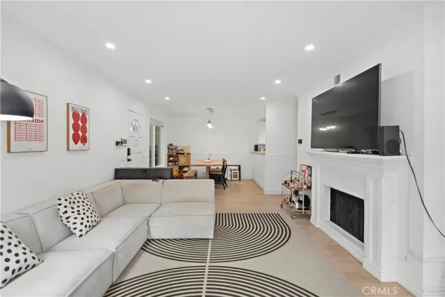 a kitchen with stainless steel appliances granite countertop a sink dishwasher a stove a dining table and chairs with wooden floor