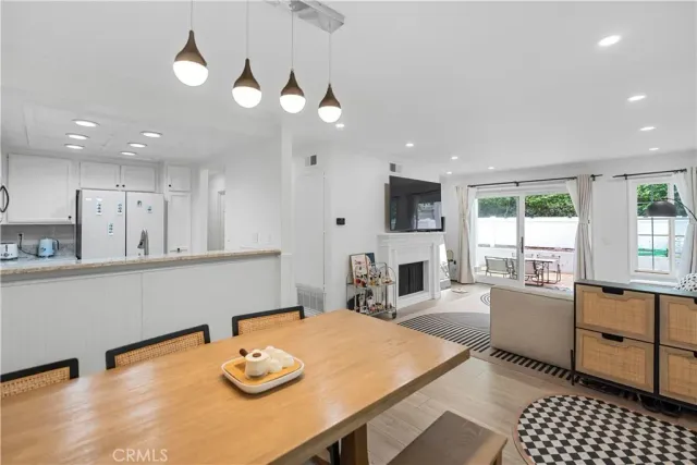 a kitchen with stainless steel appliances granite countertop a sink dishwasher a stove a dining table and chairs with wooden floor