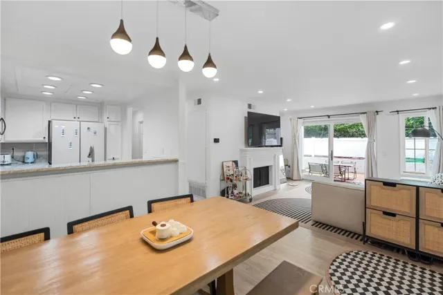 a kitchen with stainless steel appliances granite countertop a sink dishwasher a stove a dining table and chairs with wooden floor