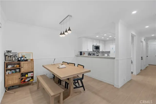 a room with stainless steel appliances kitchen island a table and chairs in it