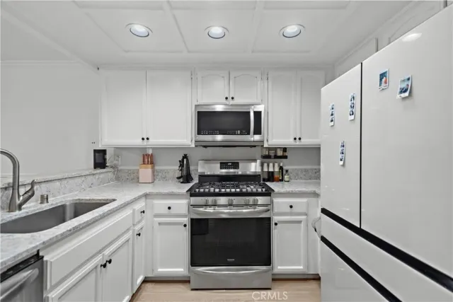 a kitchen with stainless steel appliances a stove a sink and a refrigerator