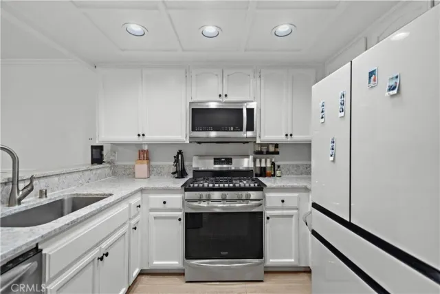 a kitchen with stainless steel appliances a stove a sink and a refrigerator