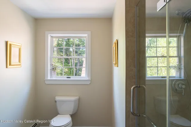 a bathroom with a toilet sink vanity and windows
