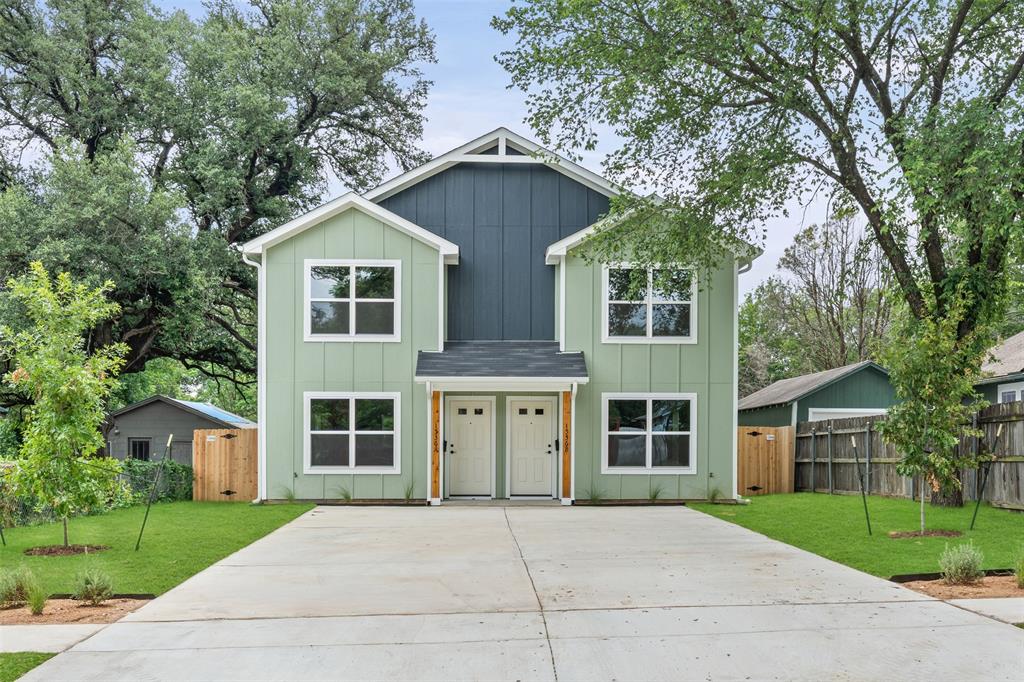 Contemporary duplex featuring a light green and dark blue vertical siding exterior