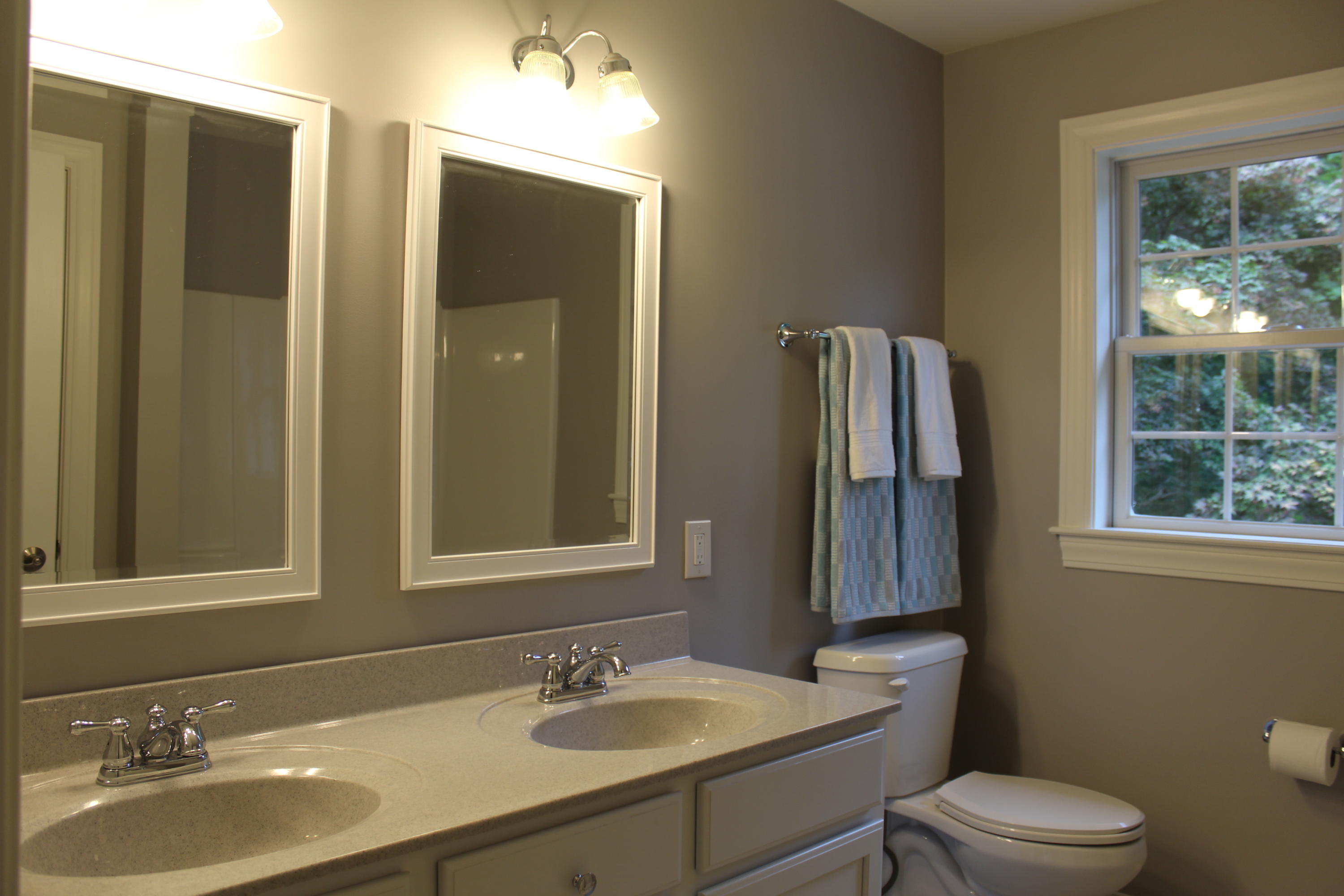 16 Knollwood Road Norwalk, CT 06854 - Photo 18 of 29 a bathroom with a toilet a sink a mirror a window and vanity