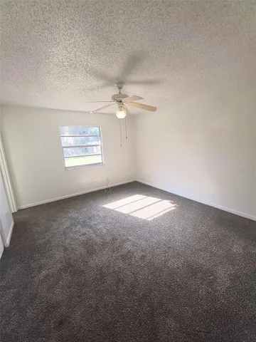 an empty room with a ceiling fan and hardwood floor