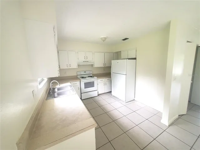 a kitchen with stainless steel appliances a refrigerator sink and cabinets