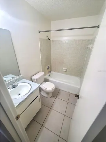 a bathroom with a granite countertop sink a toilet a mirror and shower