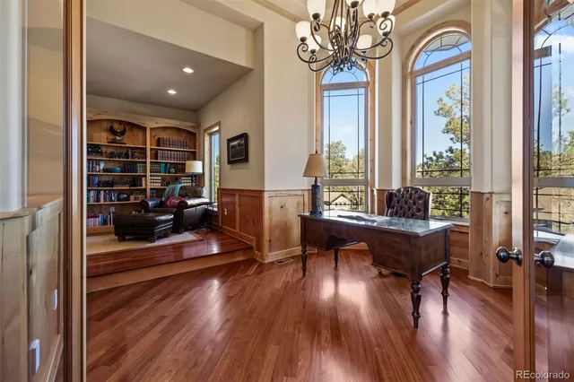 a living room with furniture a wooden floor and large window with wooden floor