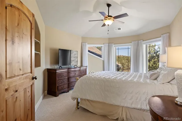 a bedroom with a bed and a chandelier with a flat tv screen