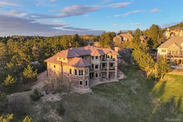 a front view of a house with a yard and mountain view in back