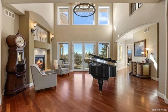 a living room with furniture a fireplace a clock and a large window