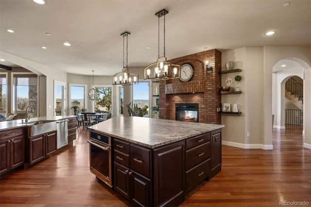 a large kitchen with stainless steel appliances granite countertop a stove and a wooden floors