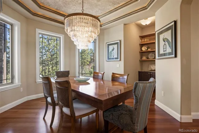 a view of a dining room with furniture wooden floor and chandelier