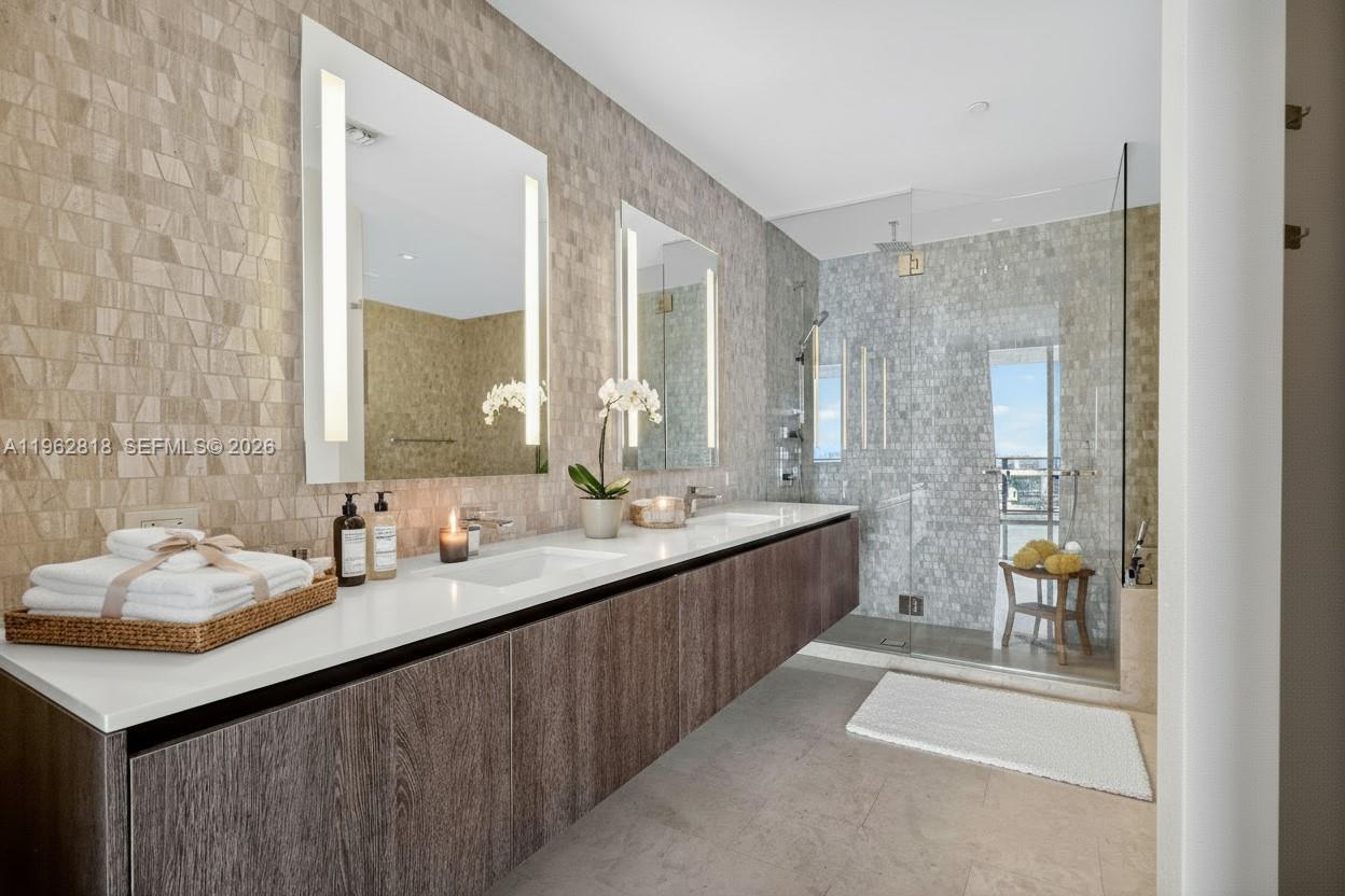 88 Southwest 7th Street, Unit 2402 Miami, FL 33130 - Photo 15 of 38 a bathroom with a sink double vanity granite tub shower and a mirror
