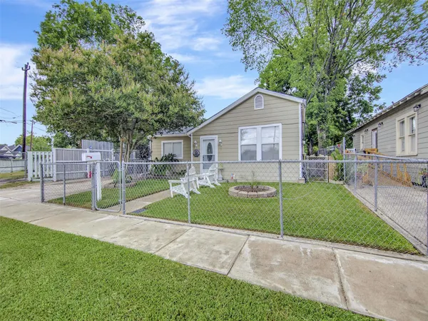 a view of a house with a backyard and a tree