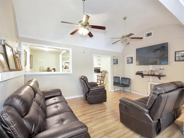 a living room with furniture a flat screen tv and kitchen view