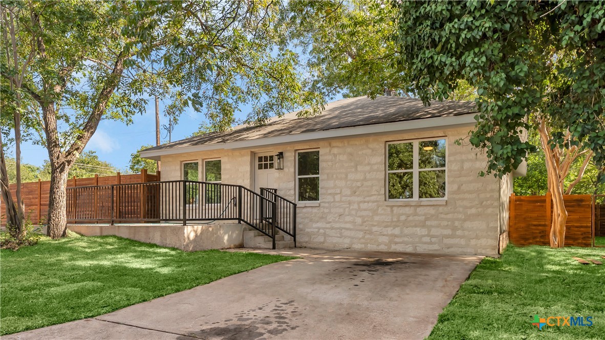 a white house that has tree in front of it