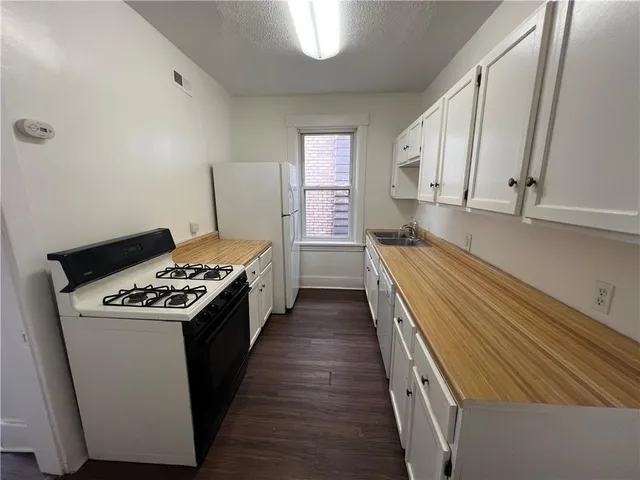 a kitchen with granite countertop a stove and a sink
