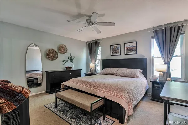 a spacious bedroom with a bed a dresser and a large mirror