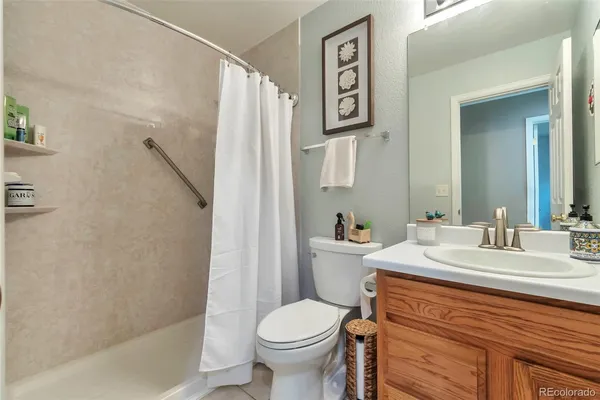 a bathroom with a granite countertop toilet sink and mirror