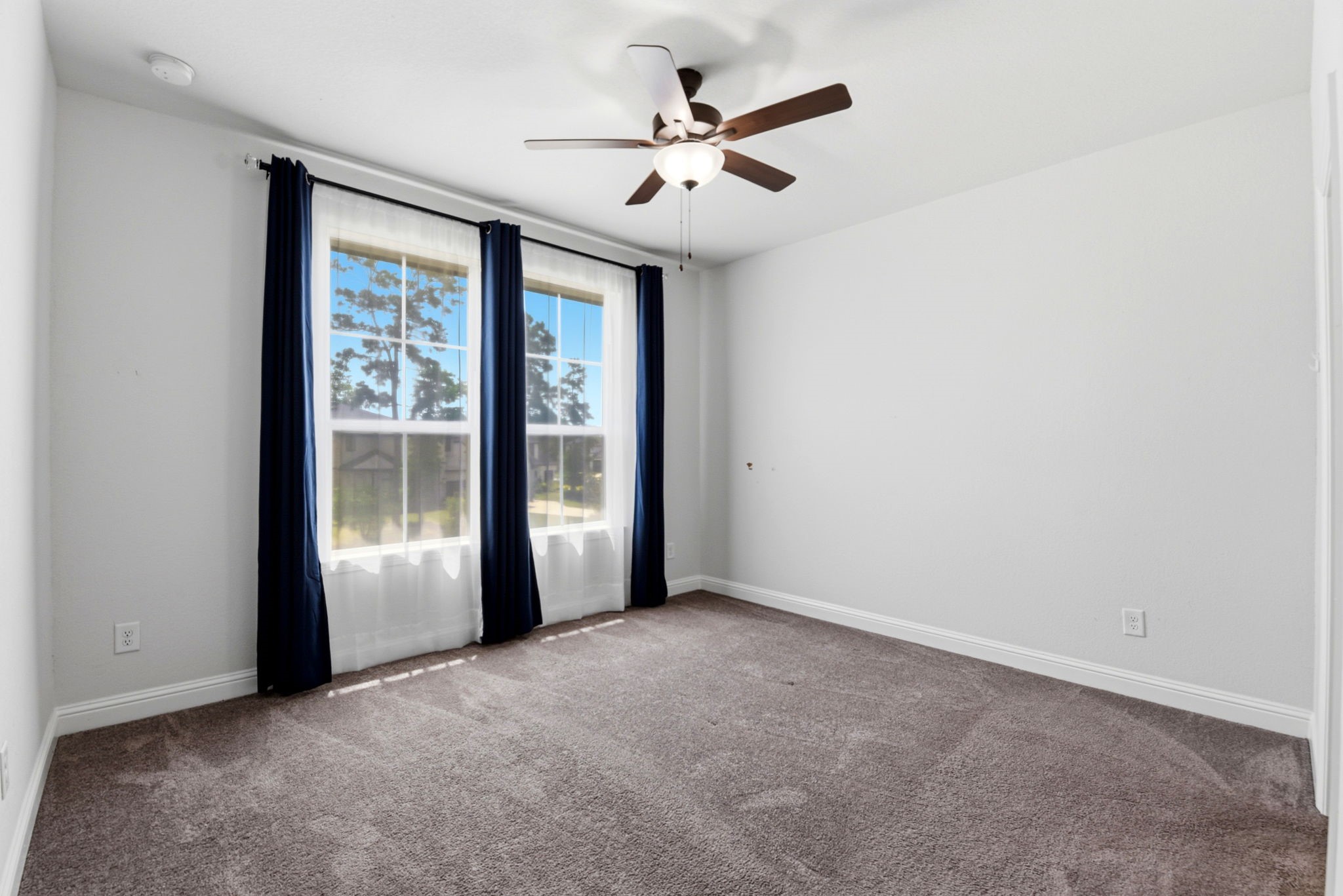 10062 South Goshawk Trail Conroe, TX 77385 - Photo 35 of 43 an empty room with windows and ceiling fan