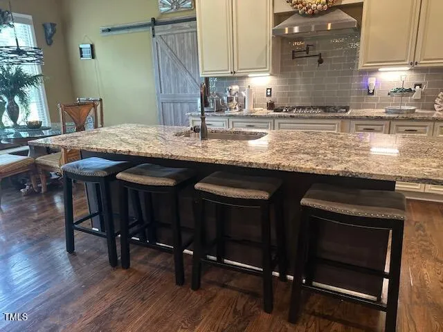 a kitchen with kitchen island granite countertop wooden floors and wooden cabinets