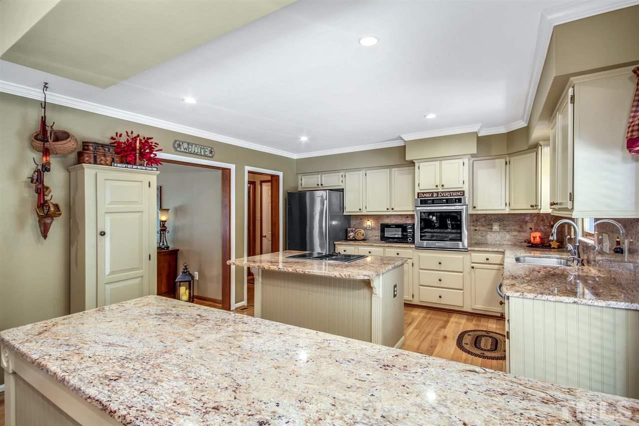 3148 Mt Vernon Church Road Raleigh, NC 27613 - Photo 11 of 29 a kitchen with stainless steel appliances granite countertop a sink dishwasher stove refrigerator and microwave with wooden floor