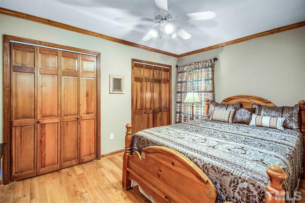 3148 Mt Vernon Church Road Raleigh, NC 27613 - Photo 19 of 29 a bedroom with a large bed and a chandelier