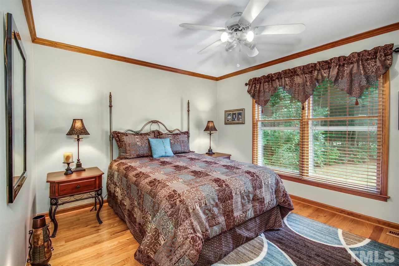3148 Mt Vernon Church Road Raleigh, NC 27613 - Photo 21 of 29 a bedroom with a bed and a chandelier