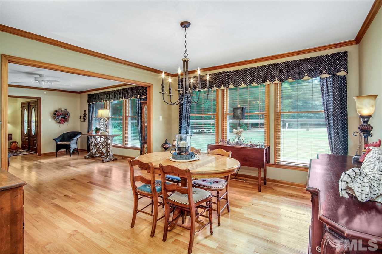 3148 Mt Vernon Church Road Raleigh, NC 27613 - Photo 8 of 29 a dining room with furniture a chandelier and wooden floor