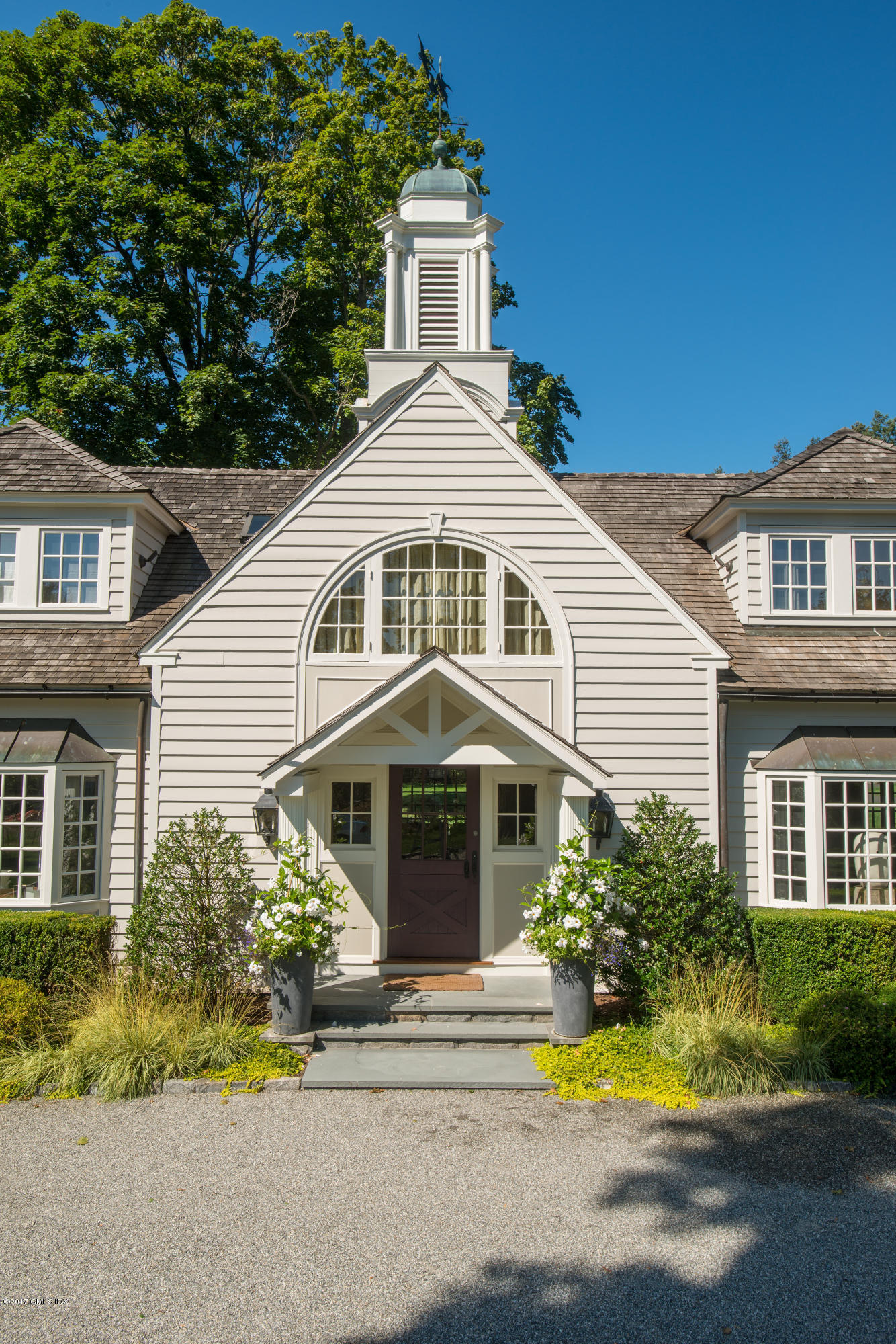 8 Mountain Wood Drive Greenwich, CT 06830 - Photo 2 of 22 a front view of a house with a yard and potted plants